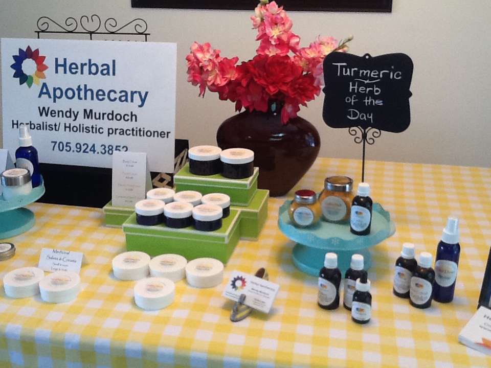 A yellow checker tablecloth with jars, bottles, and essential oils arranged on it.