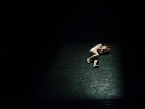 A depressed person lying in  a very dark place.