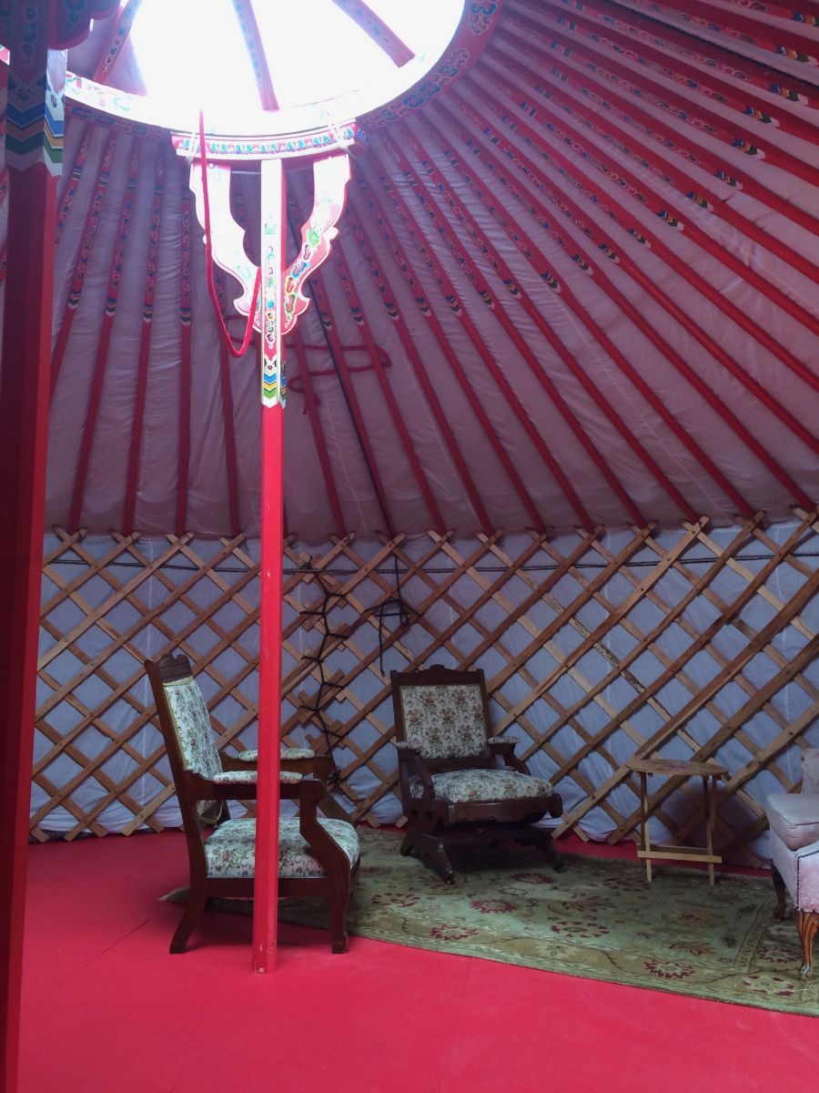 Inside of a yurt with red and white interior and two chairs 